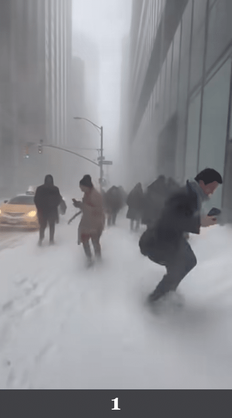 Mehrere Personen kämpfen sich durch starken Schneesturm in einer verschneiten Innenstadtstraße. Beschreibung: Straßenszene mit starkem Schneefall, mehrere Personen bewegen sich gegen den Wind. Fahrzeuge und Gebäude sind verschneit, Lichtquellen leuchten diffus durch den Schneefall. Könnte das real sein? Nein. Die Schneestruktur wirkt flächig modelliert, Bewegungen erscheinen generisch und der Schneefall hat eine gleichmäßige Partikelstruktur ohne natürliche Turbulenzen.