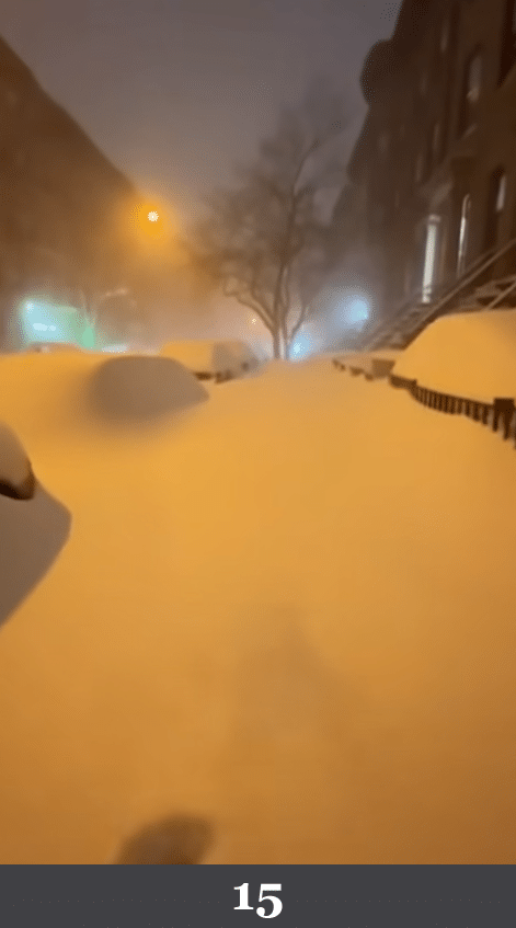 Nachtaufnahme einer verschneiten Straße mit weichem Licht und dichtem Schneefall. Beschreibung: Straßenlaternen erzeugen gleichmäßige Lichtkegel, Schneefall wirkt wie ein digitaler Partikeleffekt vor dunklem Hintergrund. Könnte das real sein? Nein. Der Schneefall erscheint als gleichmäßige Textur, Fahrzeugkanten und Details zeigen typische KI-Weichzeichnung.
