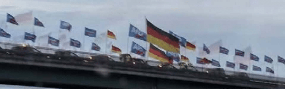 Zoom auf die Fahnenreihe im Weidel-Foto mit sichtbaren halbdurchsichtigen Doppelungen