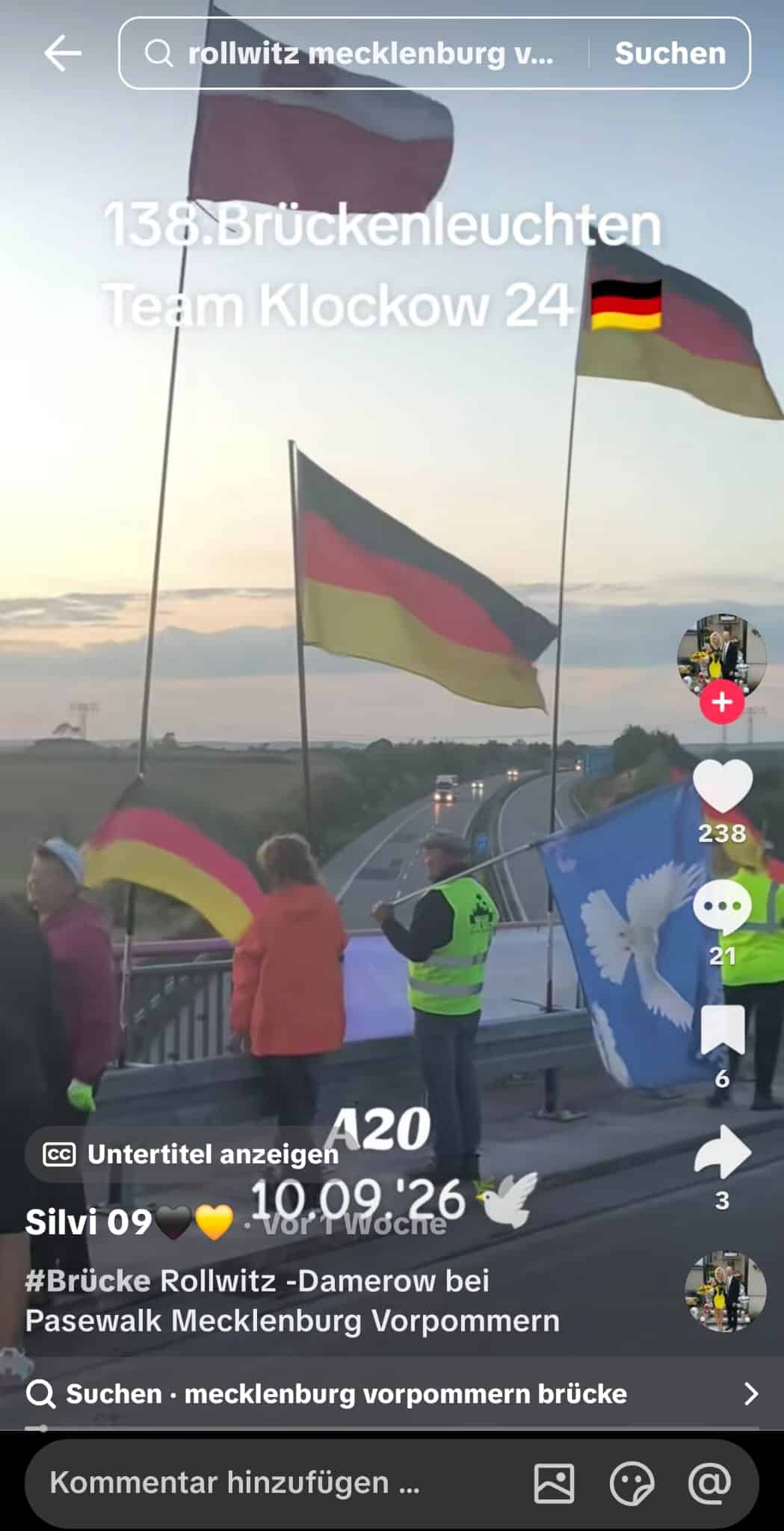 Standbild vom 10. September 2026: Deutschlandfahnen und Friedenstaube, kleine Gruppe am Geländer